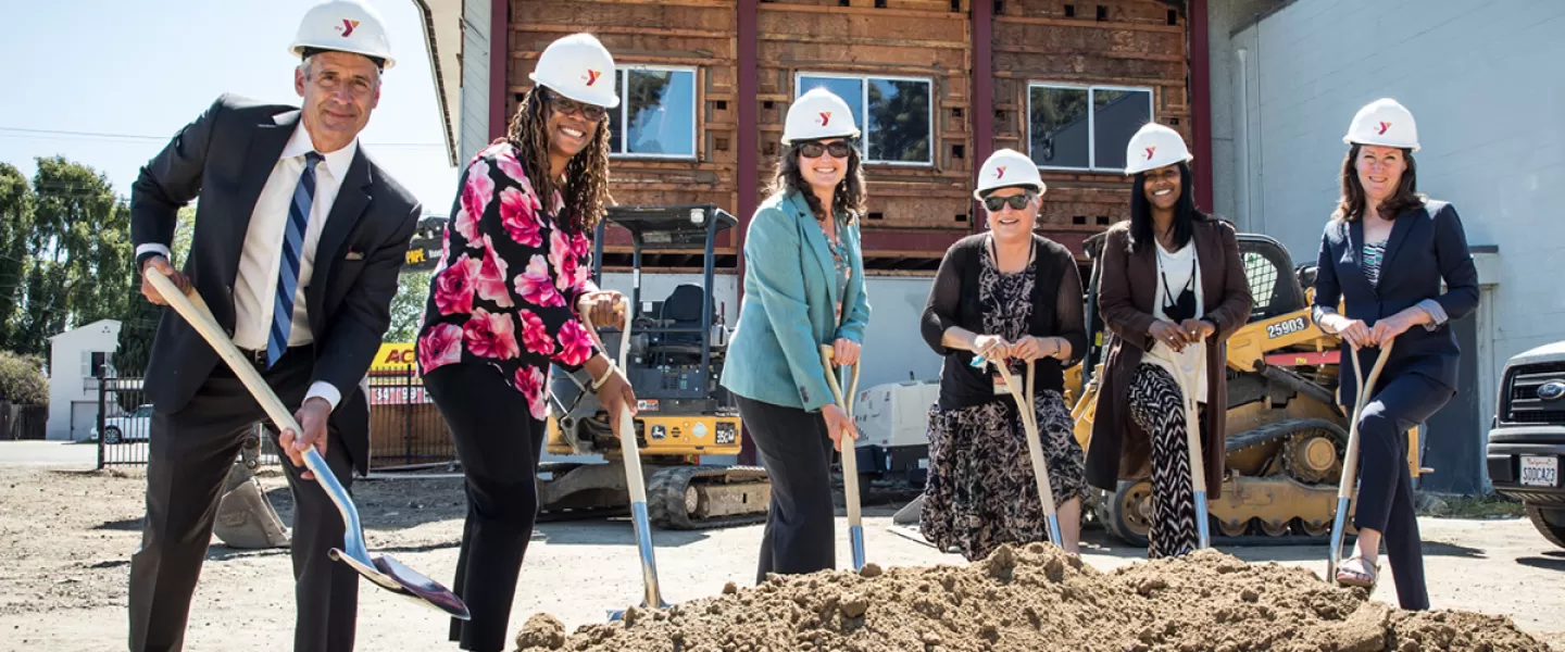 Group with hard hats and shovels breakign ground at new early learning center 